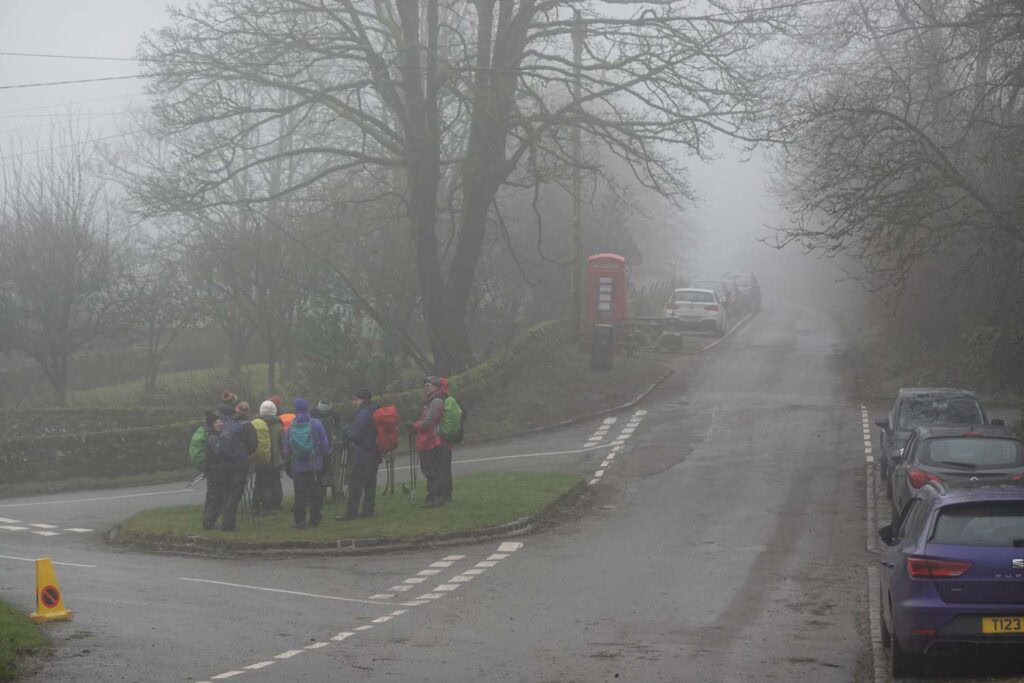 Group of hikers gathering at the roadside in Hollinsclough near Chrome Hill, in misty conditions as they prepare to start one of the popular Chrome Hill walks in the Peak District.
