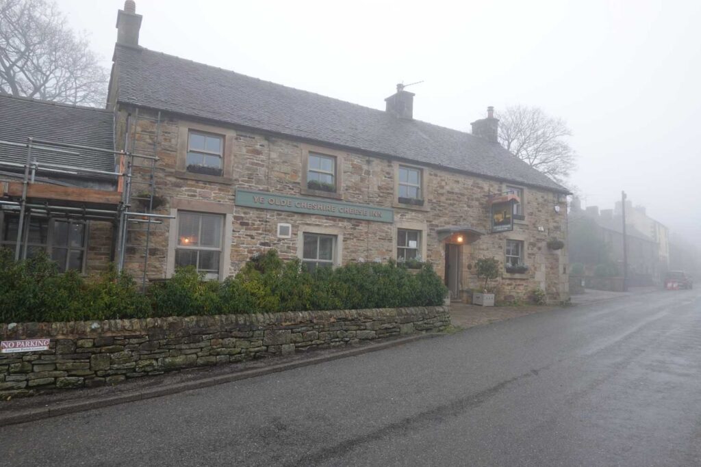 Exterior of Ye Olde Cheshire Cheese Inn in Longnor, a traditional stone-built village pub on a misty day